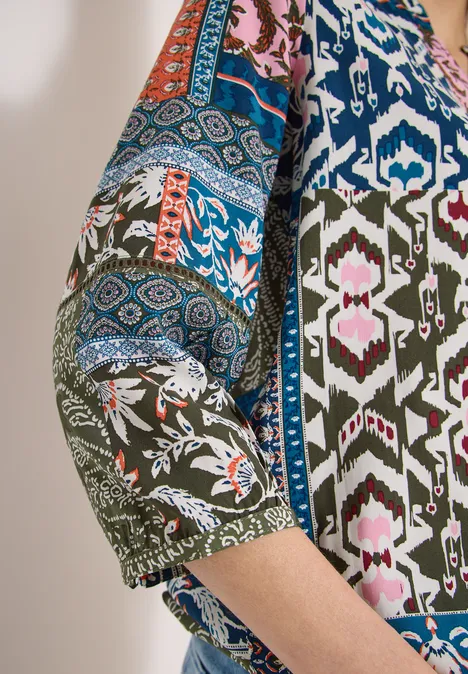 Gekleurde top met 3/4-mouwen en abstracte, etnische patronen.