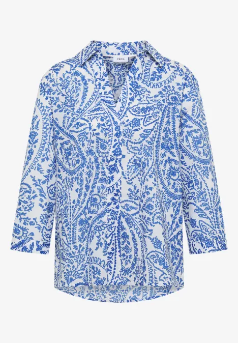 Damesblouse met blauw paisley-patroon op witte achtergrond.