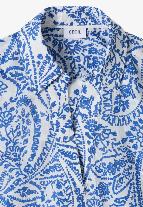 Witte blouse met blauw paisley-patroon, kraag en los gestrikt lint voor.