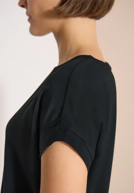 Seitenansicht einer Frau im schwarzen T-Shirt