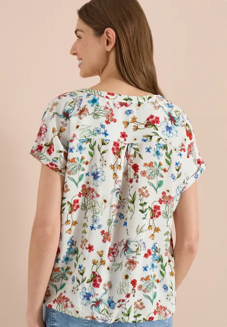 Damesblouse wit met kleurrijke bloemenprint, korte mouwen, losse pasvorm, achteraanzicht.