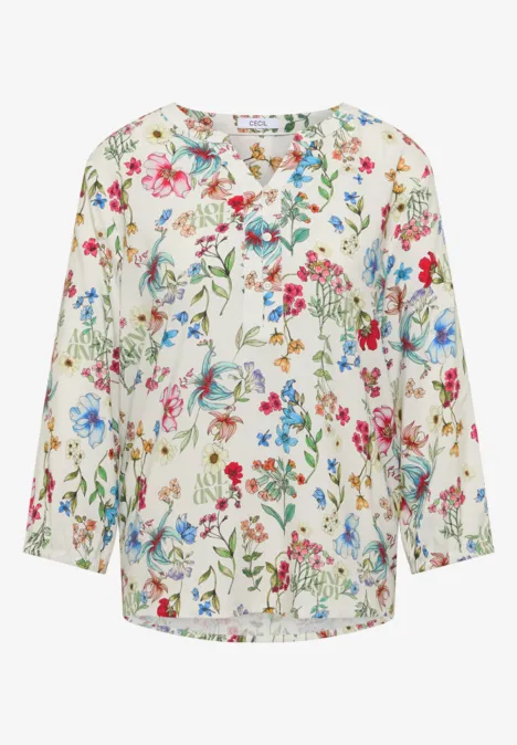 Weiße Bluse mit buntem Blumenmuster und langen Ärmeln.
