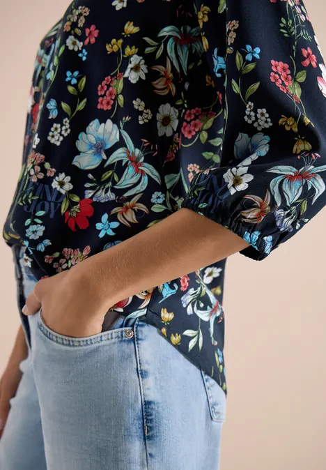 3/4-Arm Bluse mit Split Neck und Print universal blue Damenoberteil mit buntem Blumenmuster, halblangem Ärmel, kombiniert mit hellblauen Jeans; Hand steckt in Tasche.