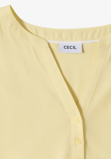 Hellgelbe Damenbluse mit V-Ausschnitt und Knopfleiste, Label 'CECIL' sichtbar.