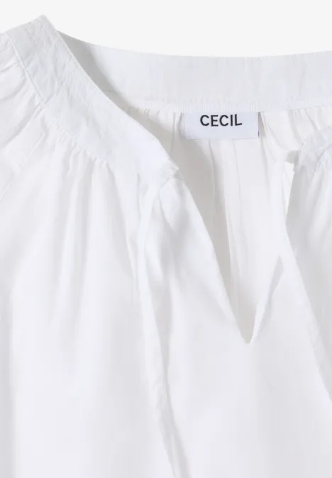Weißes Damenoberteil mit mandelförmigem Ausschnitt und Markenlabel "CECIL" am Kragen