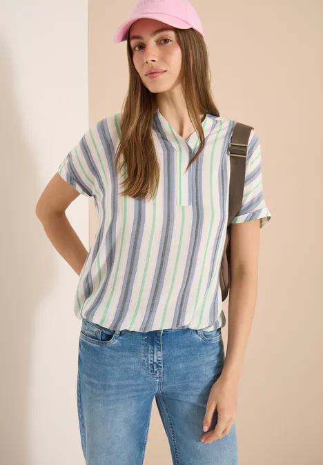 Kurzarm Bluse mit Split Neck und Streifen vanilla white Frau in gestreiftem Hemd und Jeans vor hellem Hintergrund, Gesicht unkenntlich.