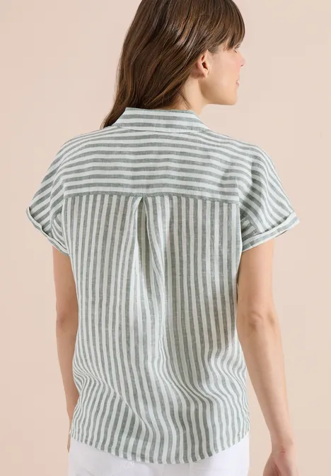 Femme de dos portant une chemise ample à manches courtes rayée blanc et vert.