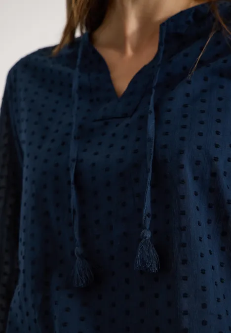 Donkerblauwe blouse met fijn ajourpatroon en koordjes bij de V-hals.