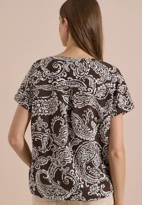 Blouse met split in de hals en print brown cacao Rückansicht einer Frau in lockerem Kurzarmshirt mit schwarz-weißem Paisley-Print.