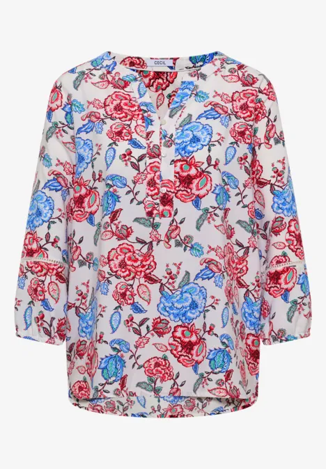 Witte blouse met rood-blauw bloemenpatroon, losse pasvorm, driekwart mouwen en ronde hals.
