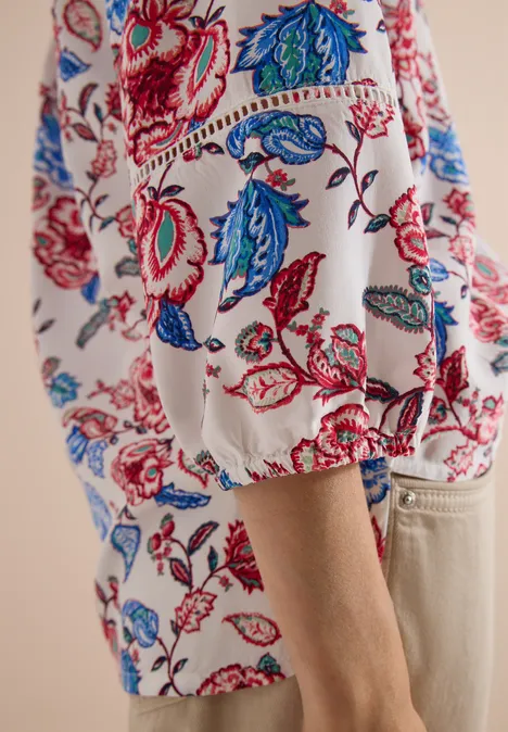Witte blouse met kleurrijke rode en blauwe bloemenprint en losse pofmouw