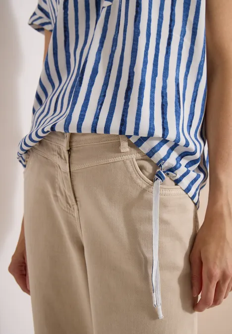 Dropped Shoulder Bluse mit Streifen urban navy blue Person trägt beige Hose und blau-weiß gestreiftes Shirt, sichtbare Hände und ein hängender Kordelzug.