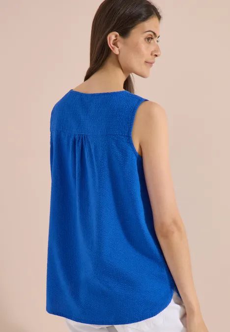 Blusentop mit Split Neck und Bändern surf blue Eine Frau trägt von hinten ein ärmelloses, weites Top in Königsblau.