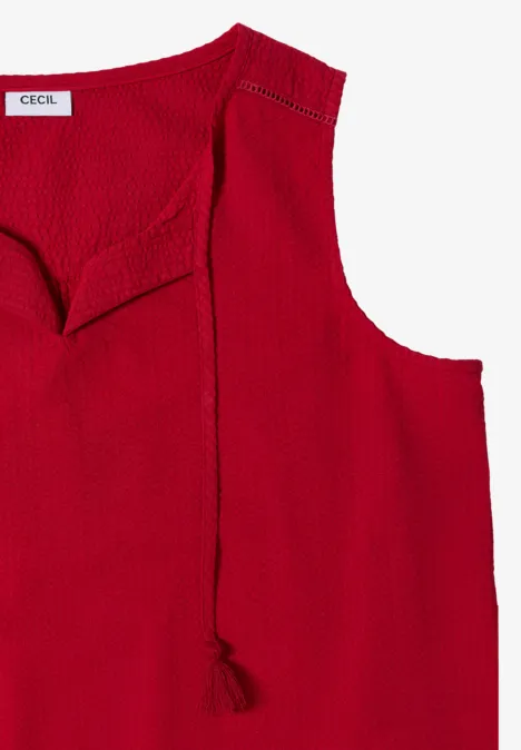 Haut sans manches rouge en maille, col rond, coupe décontractée avec pompon décoratif.