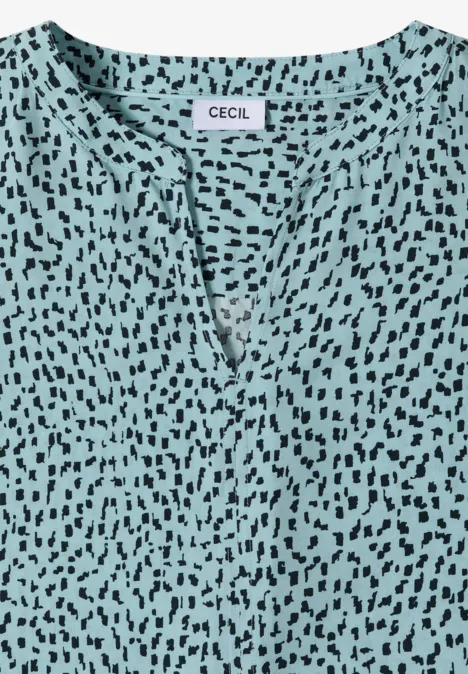 Türkisfarbenes Damenoberteil mit V-Ausschnitt und schwarzem Fleckenmuster, Label 'CECIL'.