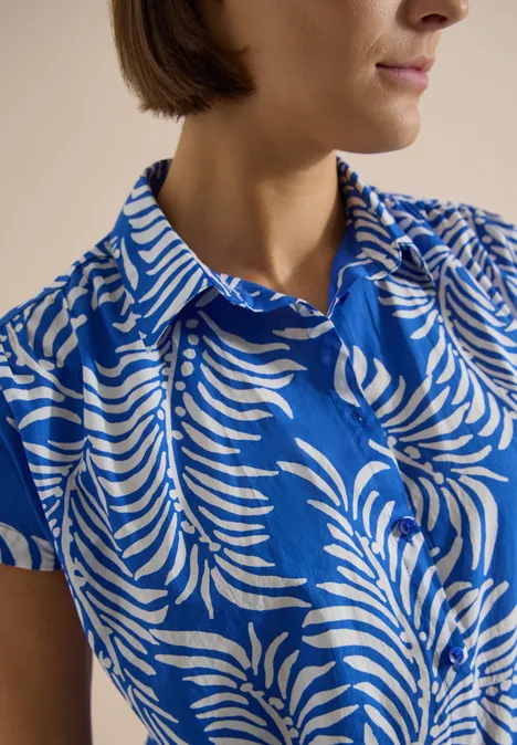 Kurzarm Hemdbluse mit Print surf blue Frau in blau-weiß gemustertem Hemd mit Blattmotiven, Kragen und kurzen Ärmeln.