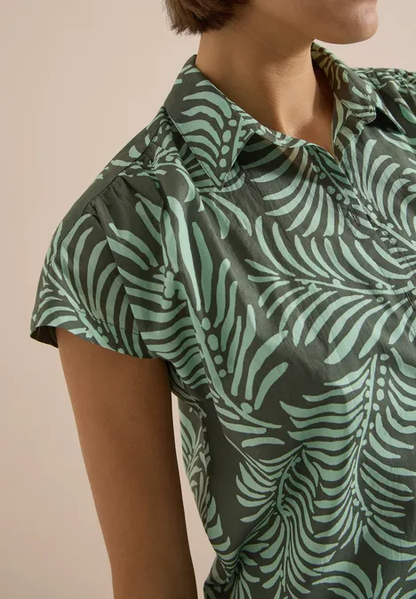 Kurzarm Hemdbluse mit Print khaki Nahaufnahme einer Frau in kurzärmligem Hemd mit grünem Blattmuster