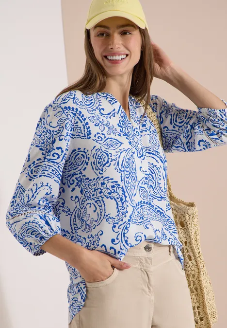 Tuniek met 3/4-mouwen en print vanilla white Bluse in Weiß mit blauem Paisley-Muster, beige Hose, Strohtasche und Haarband