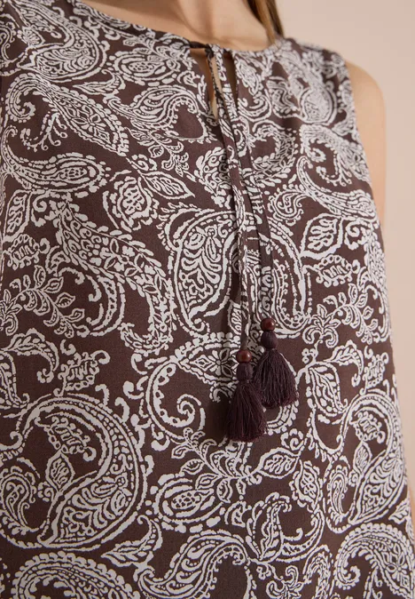 Braunes ärmelloses Top mit weißem Paisley-Muster und Quasten am Rundhalsausschnitt.