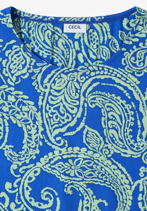 Nahaufnahme eines blauen Oberteils mit hellgrünem Paisley- und Blumenmuster, Label "CECIL" sichtbar