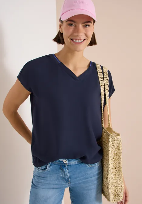 Kurzarm Blusenshirt mit Strukturmix urban dark blue Frau in dunkelblauer Bluse und Jeans mit geflochtenem Korbtasche über der Schulter.