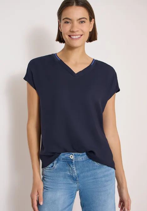 Kurzarm Blusenshirt mit Strukturmix urban dark blue Frau trägt ein dunkelblaues V-Ausschnittshirt mit überschnittenen Schultern und blaue Jeans