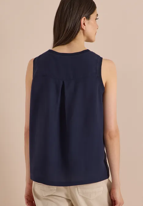 Blusentop mit Rundhals und Rippdetails urban dark blue Rückenansicht einer Person in ärmelloser, dunkelblauer Bluse mit rückseitlicher Mittelnaht und beiger Hose.