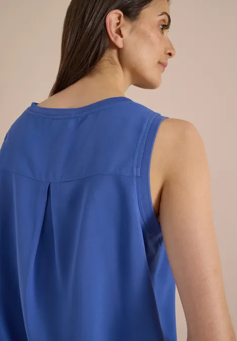 Blusentop mit Rundhals und Rippdetails deep river blue Eine Frau trägt ein ärmelloses, blaues Oberteil, Aufnahme von hinten mit lockerem Fall und kleinem Rückendetail.