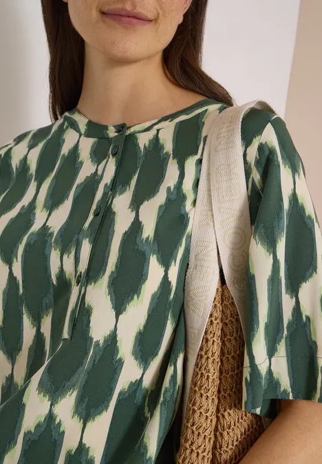 Kurzarm Bluse mit Rundhals und Print vanilla white Nahaufnahme einer Frau in grün-weiß gemustertem Oberteil mit Strohtasche über der Schulter.