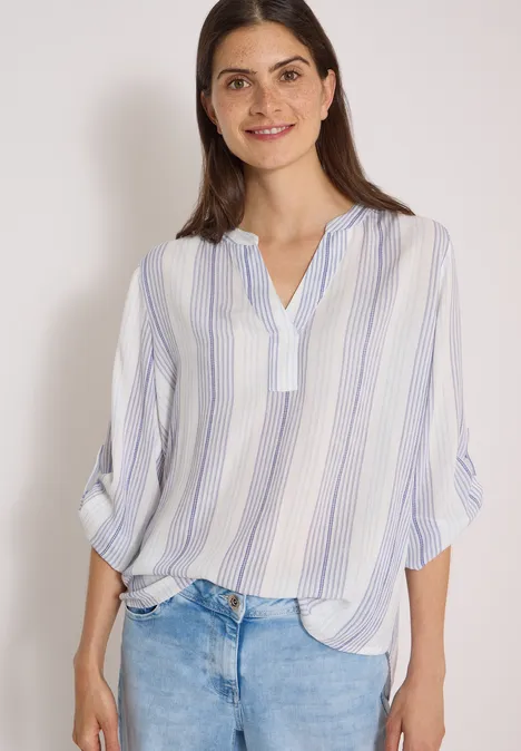 3/4-Arm Bluse mit Turn-Up und Streifen deep river blue Junge Frau mit weiß-blau gestreifter Bluse und Jeans, lächelnd vor hellem Hintergrund.