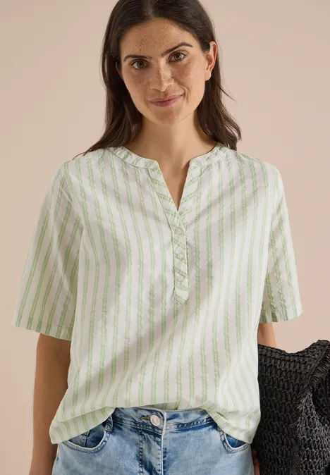 Halbarm Bluse mit Split Neck und Streifen raw matcha lime Frau trägt weiße Bluse mit grünen Streifen, V-Ausschnitt und halblangen Ärmeln.