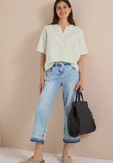 Halbarm Bluse mit Split Neck und Streifen raw matcha lime Frau im gestreiften Hemd, blauen Jeans und mit schwarzer Flecht-Tasche.