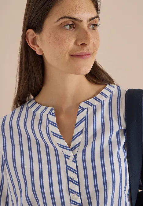 Halbarm Bluse mit Split Neck und Streifen deep river blue Frau mit dunklem Haar trägt weiße Bluse mit blauen Streifen und V-Ausschnitt.