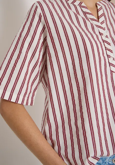 Halbarm Bluse mit Split Neck und Streifen russet red Schulter und Arm in einem weiß-roten, vertikal gestreiften Hemd, lässig geschnitten.