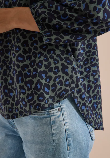 Tunique léopard à manches 3/4 et col fendu dried olive green Damenbluse mit grün-schwarz-blauem Leopardenmuster, lässig über hellblaue Jeans kombiniert
