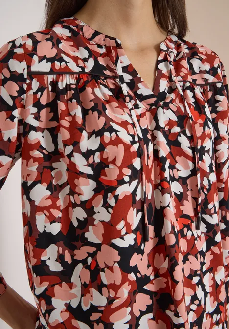 3/4-Arm Tunika mit Split Neck und Print russet red Frau trägt Bluse mit abstraktem, rot-weiß-schwarzem Blumenmuster