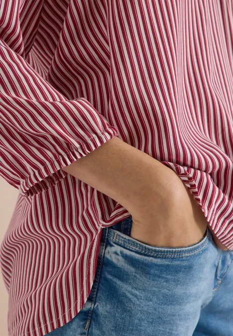 3/4-Arm Bluse mit Split Neck und Streifen russet red Person trägt rot-weiß gestreifte Bluse und blaue Jeans, eine Hand in der Tasche.
