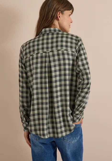 Overhemd met lange mouwen en ruitjespatroon khaki Person von hinten in grün-weiß kariertem Hemd und Jeans vor unauffälligem Hintergrund.