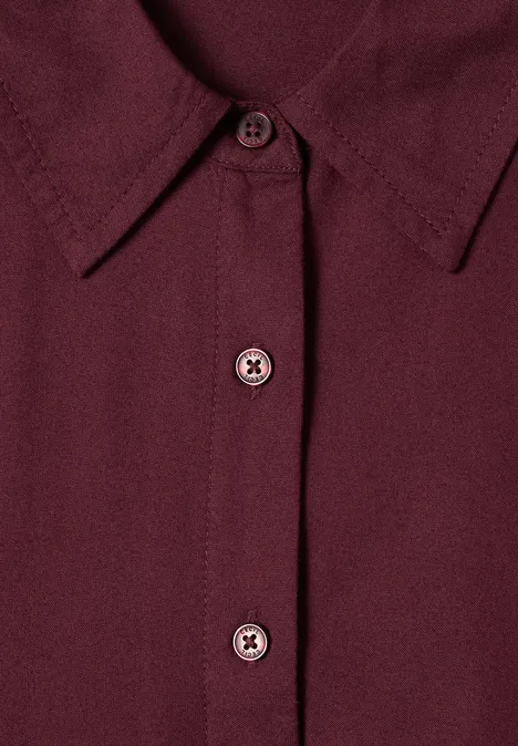 Chemisier à manches longues avec patte de boutonnage red wine Gros plan d’une chemise bordeaux avec col et deux boutons visibles