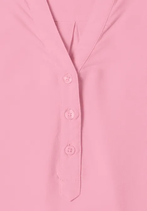 Ein rosa Oberteil mit V-Ausschnitt und drei Knöpfen.