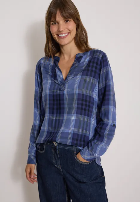 Langarm Tunika mit Karomuster urban dark blue Frau in blau kariertem Hemd und blauen Jeans lacht vor hellem Hintergrund.