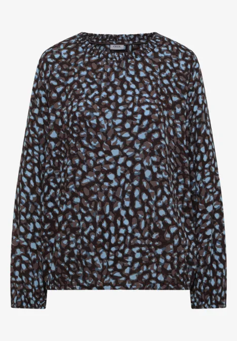 Damenbluse mit schwarzem Grund und blauem abstraktem Blattmuster, langärmlig, locker geschnitten.