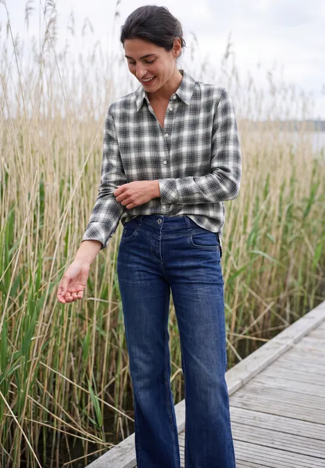 Flanellen blouse met lange mouwen en ruitjespatroon vanilla white Vrouw in geruit overhemd en spijkerbroek lacht op een vlonder tussen riet.