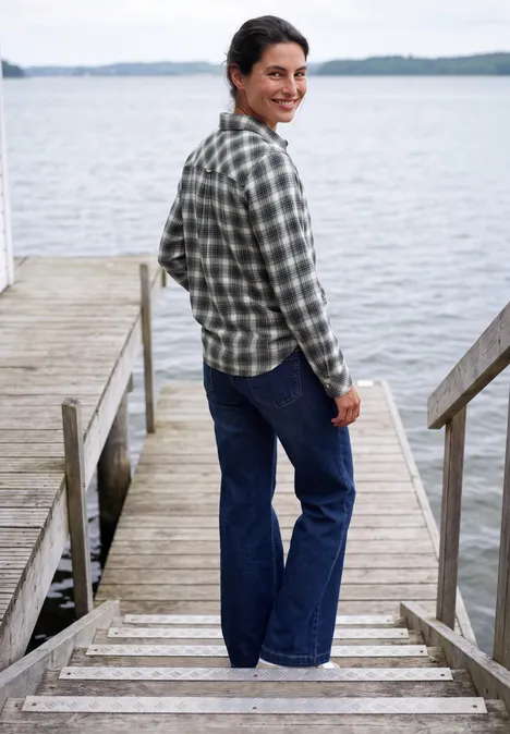 Flanellen blouse met lange mouwen en ruitjespatroon vanilla white Een vrouw staat op een steiger bij een meer, draagt een geruit overhemd en jeans, glimlacht terwijl ze omkijkt.