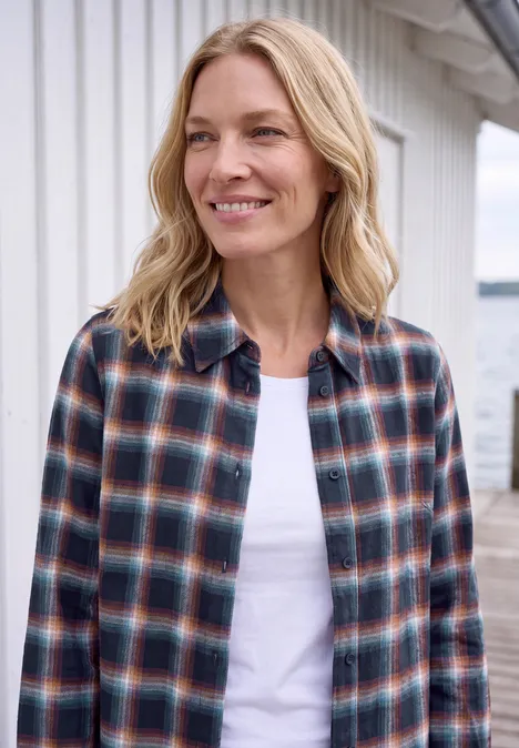 Flanellen blouse met lange mouwen en ruitjespatroon urban dark blue Een glimlachende blonde vrouw draagt een geruit overhemd op een wit t-shirt voor een licht houten huis.