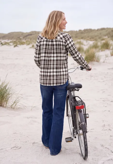 Langarm Flanell Bluse mit Karomuster truffle brown Frau in kariertem Hemd und Jeans schiebt Fahrrad am Dünenstrand entlang.