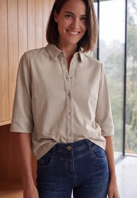 Kurzarm Hemdbluse in Unifarbe cashmere beige Eine lächelnde Frau in hellem Raum trägt eine beige Bluse mit ¾-Ärmeln und blaue Jeans.