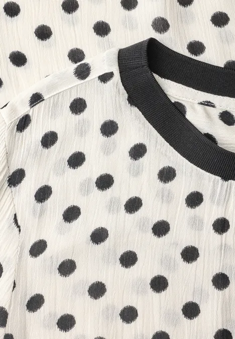 Weißes T-Shirt mit schwarzen Punkten und schwarzem Kragen.