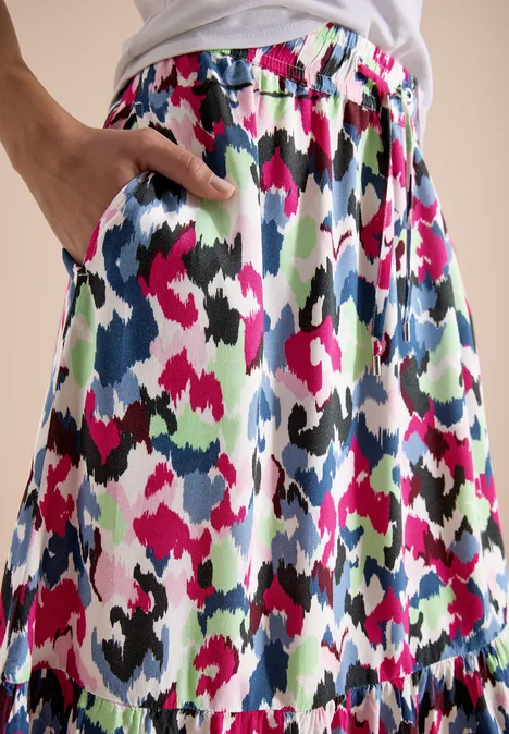 Jupe colorée à taille élastique avec poches, motif abstrait rose, vert, noir, blanc et bleu.
