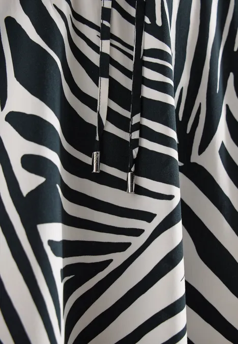 Zwart-witte stof met zebrapatroon en metalen koorduiteinden.